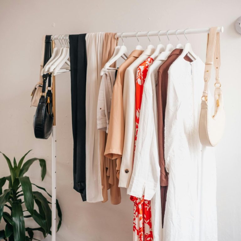 A rack displaying a selection of stylish clothing in various colours.